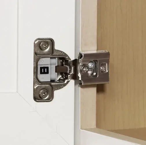 Cabinet hinge attached to the wooden face frame of a framed cabinet
