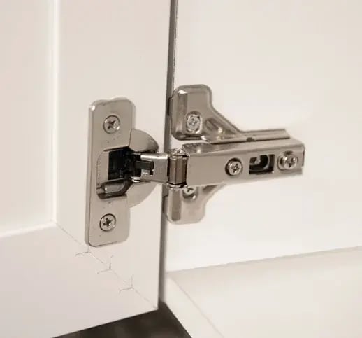 Cabinet hinge attached to the side wall of a frameless cabinet box