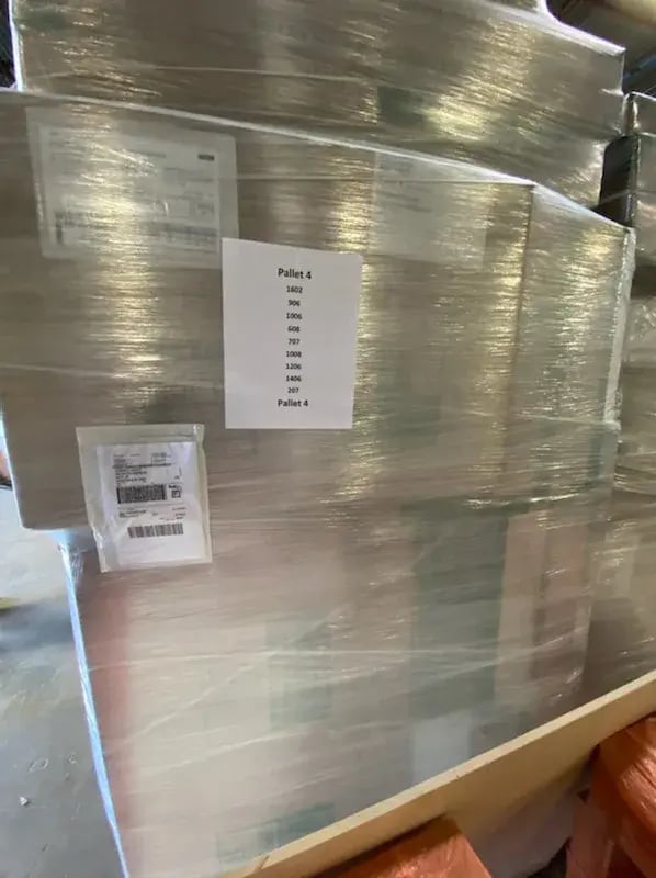 Palletized Qwikkit kits with a pallet label listing each unit on board