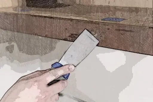Filling holes in a cabinet face with wood filler and a putty knife