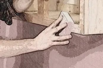 Hand sanding a cabinet surface before painting