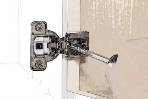Adjusting a cabinet hinge with a screwdriver to align the door