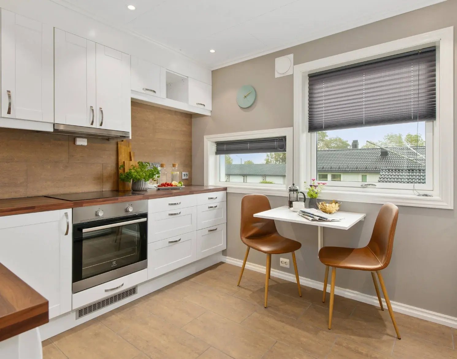 Refaced student housing kitchen with white cabinet doors and a small dining table